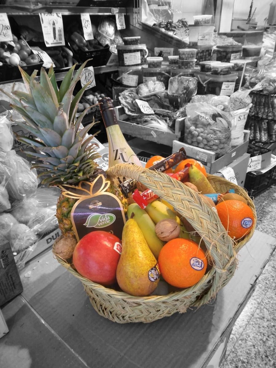 Cesta de fruta y detalles gourmet preparada para regalar